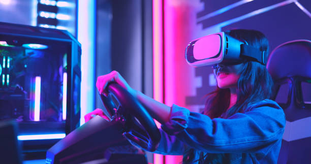 girl playing VR car racing game with a headset and a simulator steering wheel 
